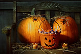 Pumpkins and spiders with candles on bench 