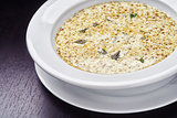 Cream soup with mushrooms and cheese on white plate