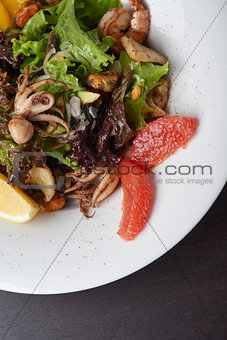 Vegetable salad with seafoods on white plate