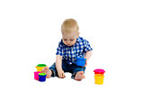 little boy in checkered shirt plays on the floor. Studio