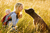 Mother, daughter and a dog in a meadow