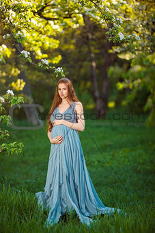 Young  pregnant woman relaxing and enjoying life in nature