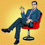 Businessman sitting in an armchair gesture okay