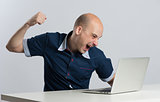 Furious man about to punch his laptop