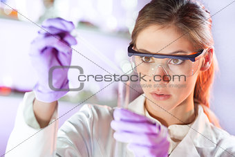 Young scientist pipetting in life science laboratory.