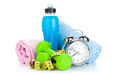 Two green dumbells, tape measure, drink bottle and alarm clock