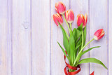 Red tulips over purple wooden table