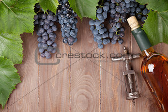 Red grape, wine bottle and vintage corkscrew
