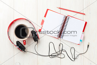 Headphones, coffee cup and notepad on desk