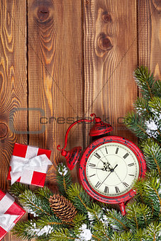 Christmas wooden background with clock, fir tree and gift boxes