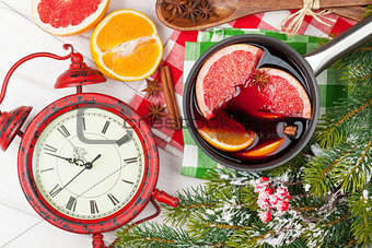Christmas mulled wine and alarm clock on wooden table