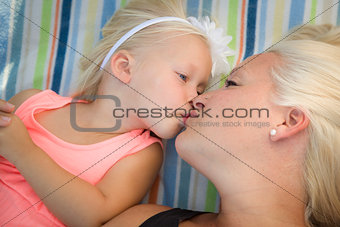 Little Girl Laying on Blanket Kisses Her Mommy