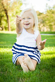 Cute Little Girl Sitting and Laughing in the Grass