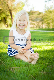 Cute Little Girl Sitting and Laughing in the Grass