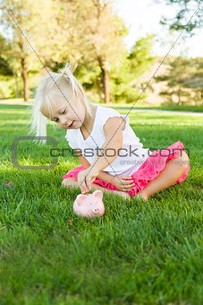 Little Girl Having Fun with Her Piggy Bank Outside