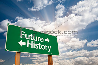 Future and History Green Road Sign Over Clouds