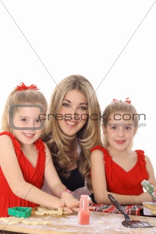 happy mom with twin daughters decorating cookies isolated on white