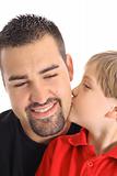 child kissing dad on the cheek isolated on white