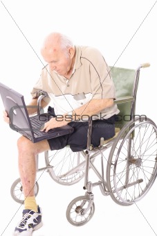 shot of an elderly man in wheelchair on laptop vertical