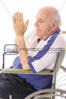 handicap senior praying in wheelchair isoalted on white