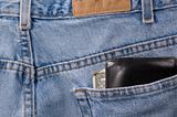 Closeup of denim blue jeans with wallet sticking out of back pocket. The edge of a credit card with "MEMBER SINCE" can be seen in the wallet.