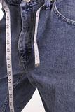 shot of weight loss jeans with measuring tape belt