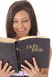 shot of a happy beautiful woman reading the Holy Bible