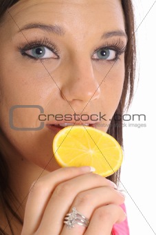 shot of a model eating an orange slice upclose