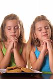shot of identical twin Sisters praying