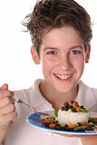shot of a happy young boy eating healthy rice, beans & veggies vertical