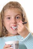 shot of a young girl eating yogurt vertical