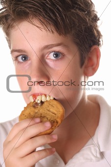shot of a young boy with rotten teeth eating a cookie