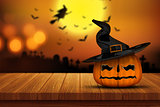 3D Halloween pumpkin on a wooden table with defocussed spooky im