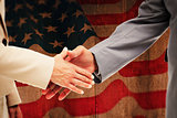 Composite image of close up of business people shaking their hands