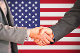 Composite image of two people having a handshake in an office