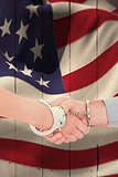 Composite image of handcuffed business people shaking hands