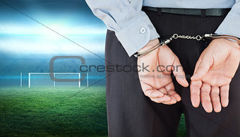 Composite image of businessman in formals with handcuffs