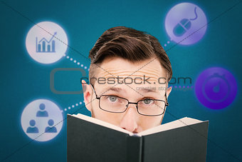 Composite image of young geek looking over black book