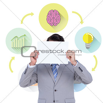 Composite image of businessman holding blank sign in front of his head