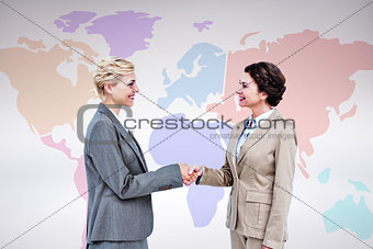 Composite image of  smiling women shaking hands