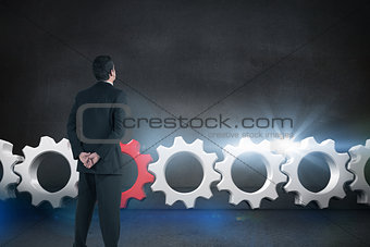 Composite image of businessman standing and looking