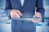 Composite image of  close up view of businessman using tablet computer