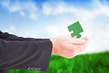 Composite image of businessman holding something with his hands