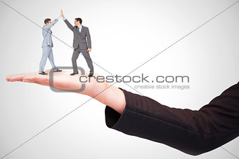 Composite image of businessmen high fiving