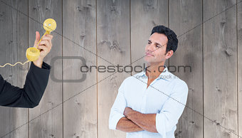 Composite image of handsome man standing with arms crossed