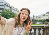 hippy woman tourist making selfie in Prague and showing victory