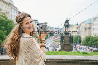 Happy hippy-looking woman tourist  with retro camera  in Prague