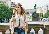 Hippie woman in bohemian clothes talking cell phone in Prague