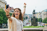 Joyful bohemian woman making selfie on Wenceslas Square, Prague