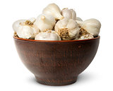In front whole head of garlic in ceramic bowl